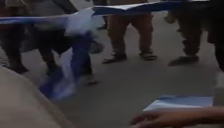 متظاهرون يمزقون لافتة إعلانية تابعة لهائل سعيد، بعد محاولة تغطية صورة الرئيس عيدروس الزُبيدي في العاصمة عدن.